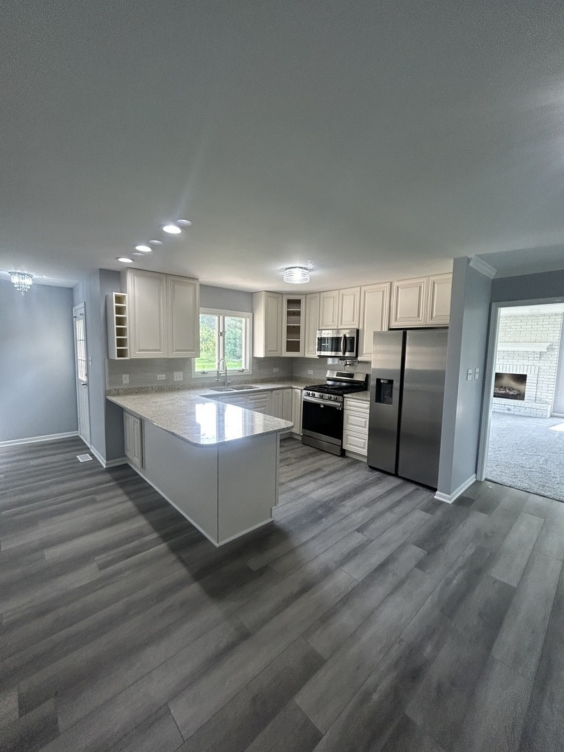 32-w320 Montgomery Road Aurora, IL 60504 - Photo 14 of 37 a large kitchen with a center island and stainless steel appliances
