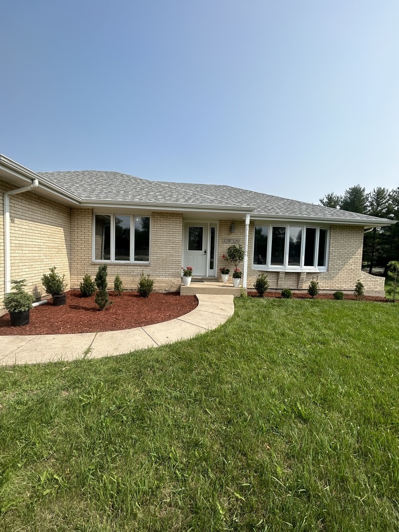 32-w320 Montgomery Road Aurora, IL 60504 - Photo 4 of 37 a front view of a house with a yard table and chairs