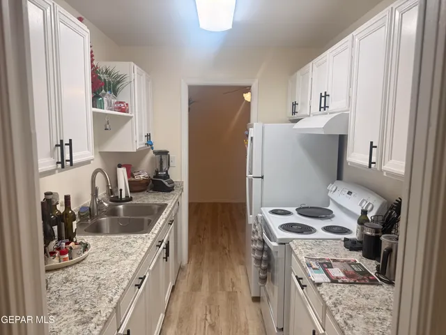 a kitchen with stainless steel appliances granite countertop a refrigerator stove and sink