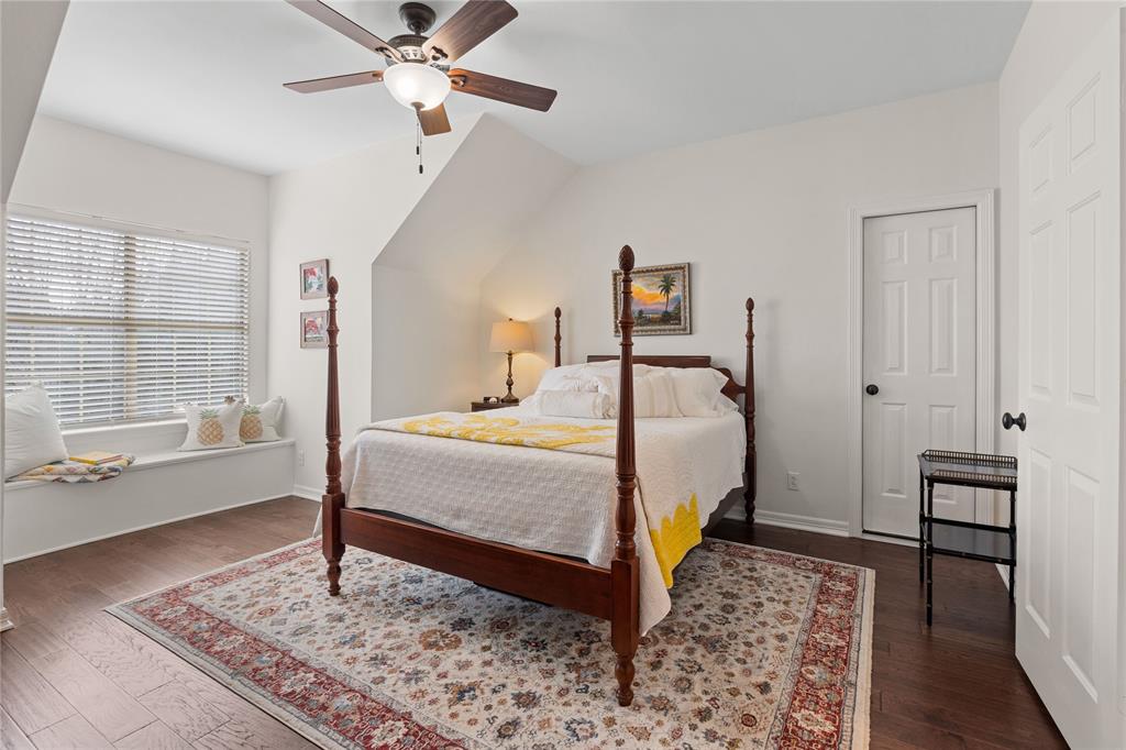 102 Weatherly Circle Rockwall, TX 75032 - Photo 25 of 39 a bedroom with a bed and a table with wooden floor