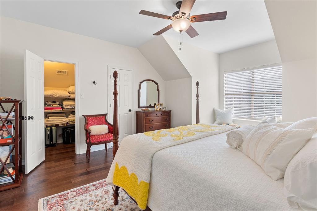 102 Weatherly Circle Rockwall, TX 75032 - Photo 26 of 39 a bedroom with a bed a chandelier and dresser