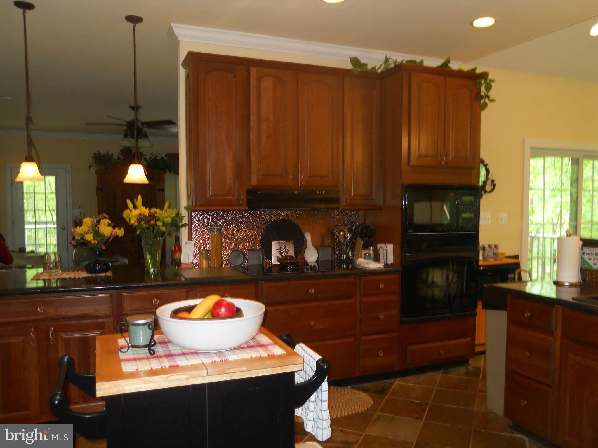 2888 Barrick Road Finksburg, MD 21048 - Photo 12 of 29 a kitchen with granite countertop a stove a oven a sink a counter and cabinets