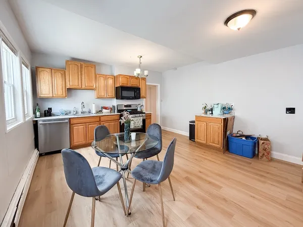 a kitchen with stainless steel appliances kitchen island granite countertop a sink a stove a dining table and chairs