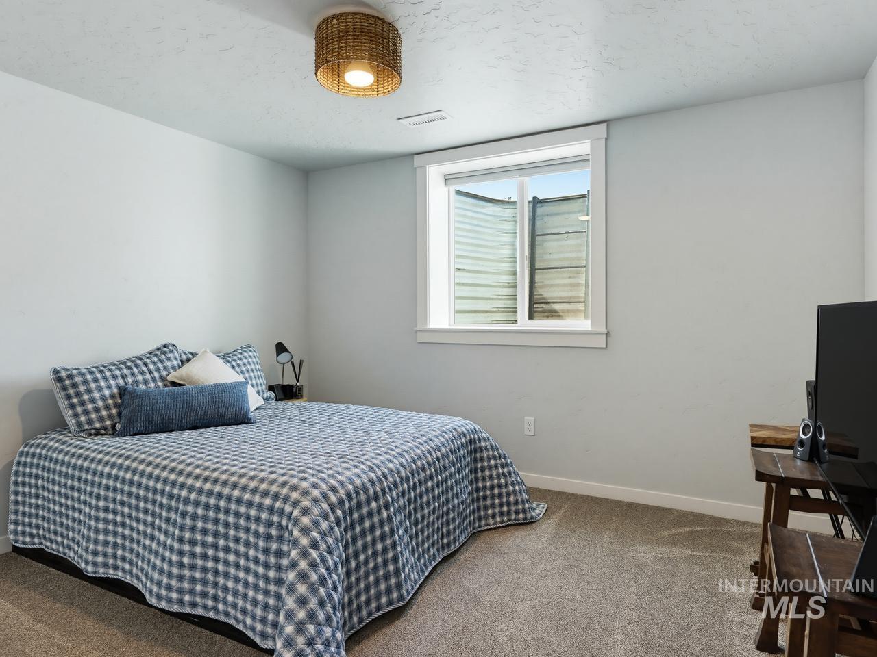 4950 West Columbia Road Nampa, ID 83687 - Photo 34 of 50 Carpeted room featuring a window with white trim, light gray walls, and a woven ceiling light fixture