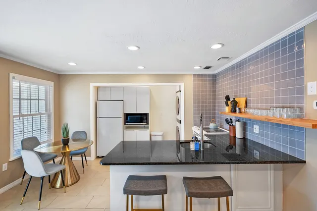 a kitchen with granite countertop sink table and chairs