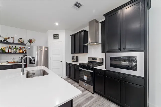 a kitchen with granite countertop a refrigerator stove and sink