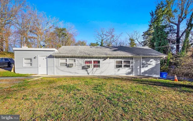 a front view of house with yard and trees in the background