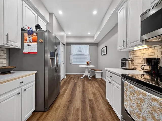 a kitchen with granite countertop a stove top oven microwave and cabinets