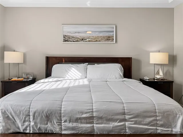 a spacious bedroom with a bed and a lamp