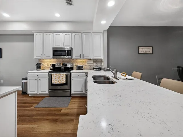 a kitchen with stainless steel appliances a stove a sink and a refrigerator