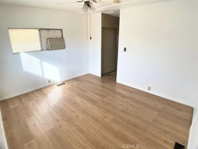a view of a big room with wooden floor and windows