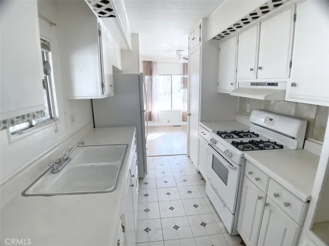 a kitchen with white cabinets and appliances
