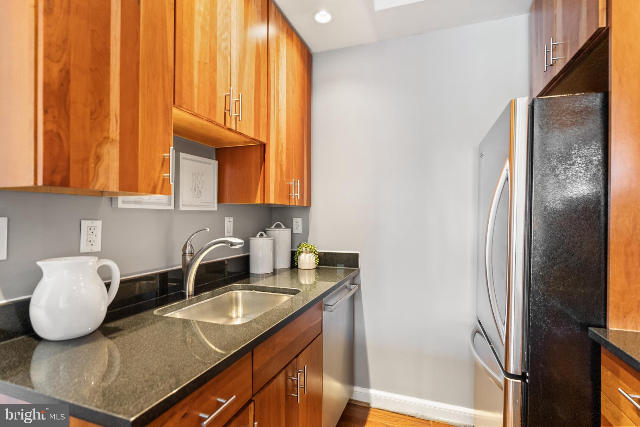 3251 Prospect Street Northwest, Unit 313 Washington, DC 20007 - Photo 14 of 43 a kitchen with stainless steel appliances granite countertop a sink and a refrigerator