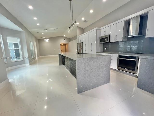 a large kitchen with stainless steel appliances kitchen island a large counter top and a sink