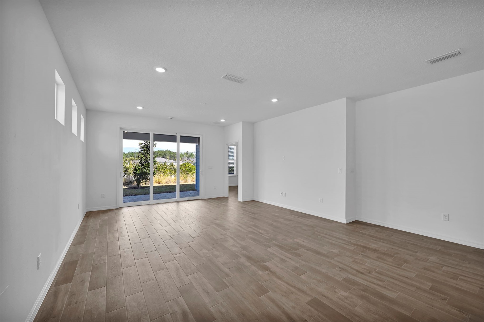 285 Ecliptic Loop Yulee, FL 32097 - Photo 11 of 42 a view of an empty room with wooden floor and a window