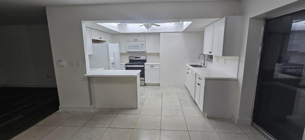 526 Reading Street Northwest Port Charlotte, FL 33952 - Photo 2 of 12 a kitchen with a sink a stove and refrigerator