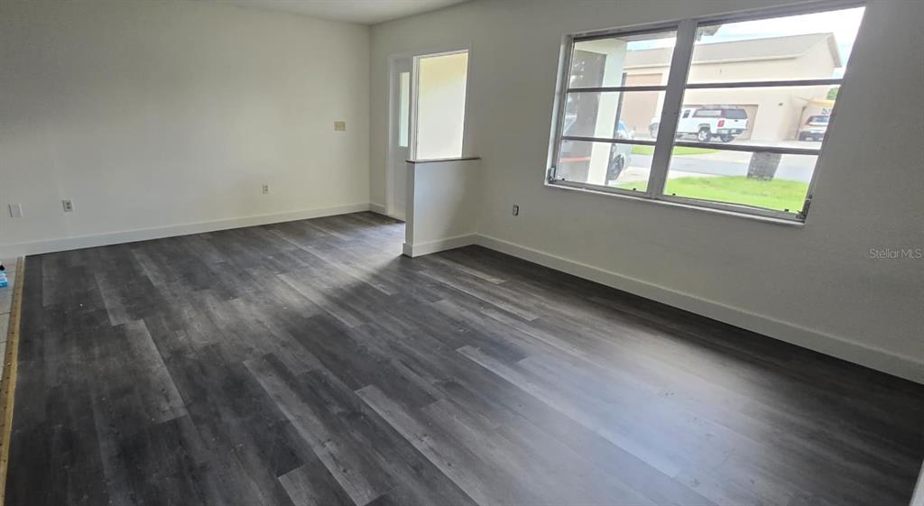 526 Reading Street Northwest Port Charlotte, FL 33952 - Photo 4 of 12 an empty room with wooden floor and windows
