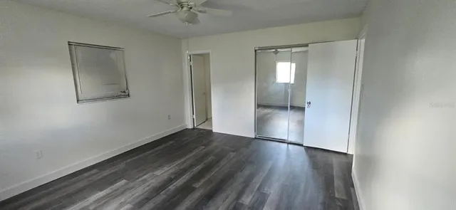 an empty room with wooden floor and a hallway
