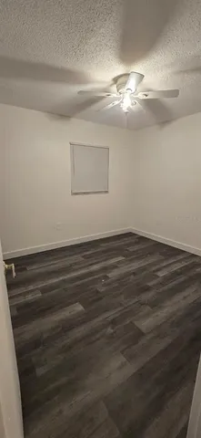 a view of a room with wooden floor and fan