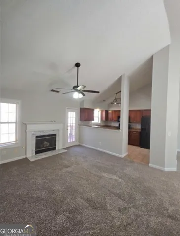an empty room with fireplace and windows