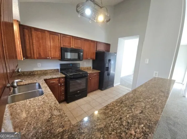 a kitchen with granite countertop a refrigerator and a sink