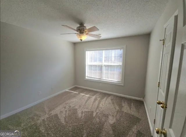 en empty room with windows and fan