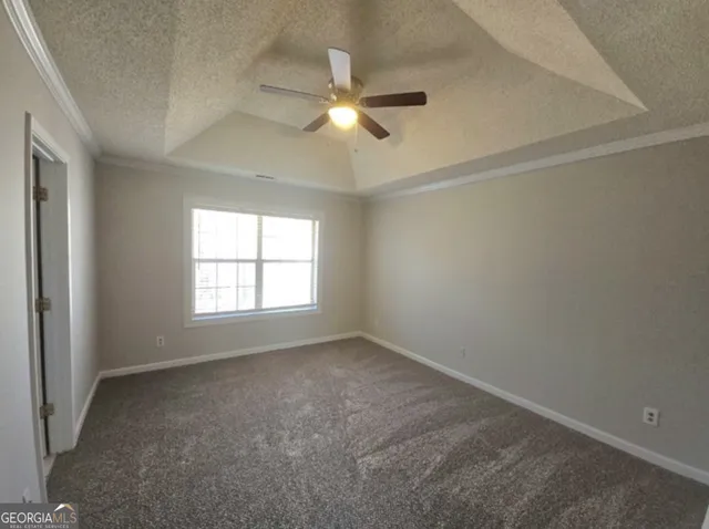 an empty room with a window and a fan
