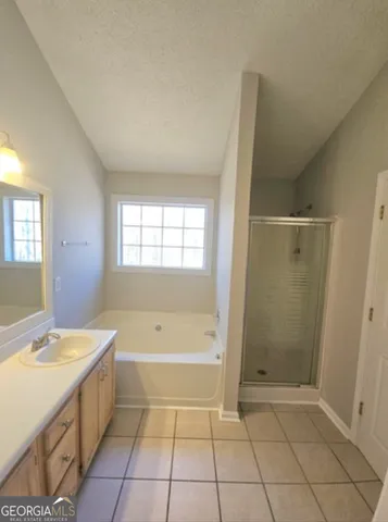 a spacious bathroom with a bathtub a sink and a shower