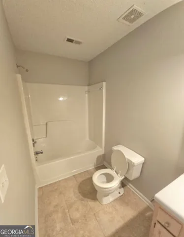 a white toilet sitting next to a bath tub