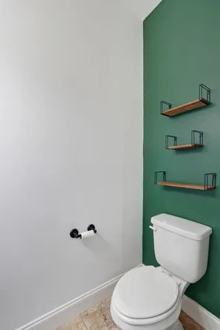 a white toilet sitting next to a shower