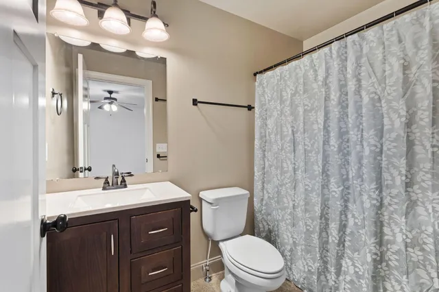 a bathroom with a sink a toilet and shower curtain