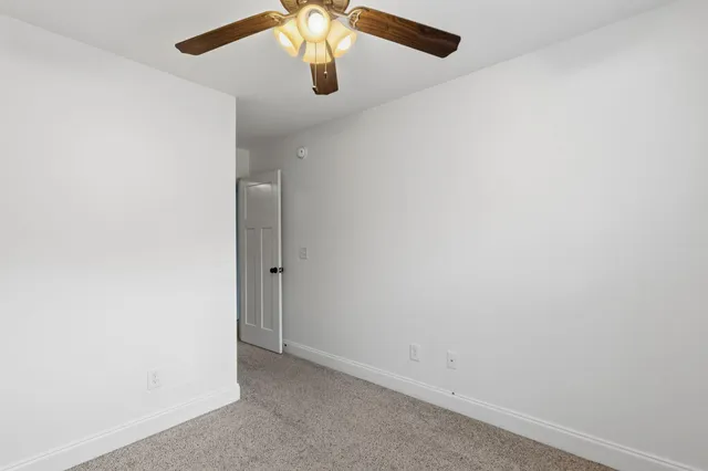 an empty room with a chandelier fan
