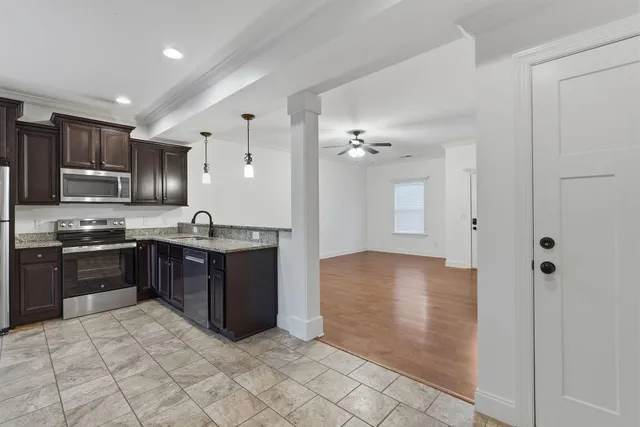 a large kitchen with stainless steel appliances granite countertop a refrigerator and a sink