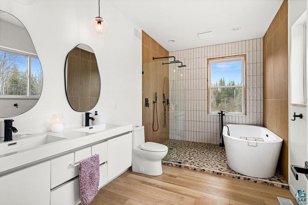 1825 East Shilhon Road Duluth, MN 55804 - Photo 25 of 37 Contemporary bathroom featuring a double vanity with integrated sinks, matte black fixtures w/double tiled showers & soaking tub.