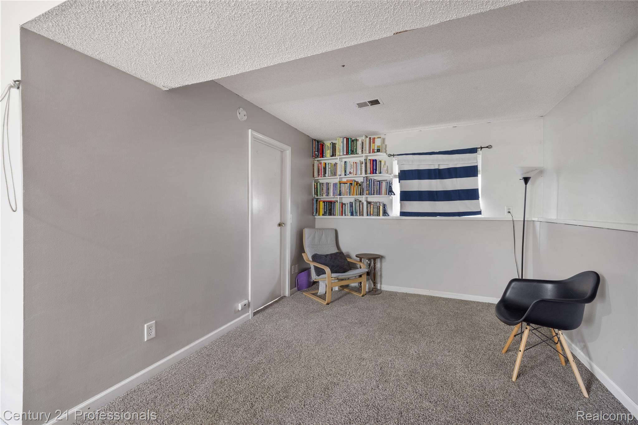 15037 Hogan Road Linden, MI 48451 - Photo 17 of 38 Carpeted room featuring a neutral color palette, built-in shelving, and a window