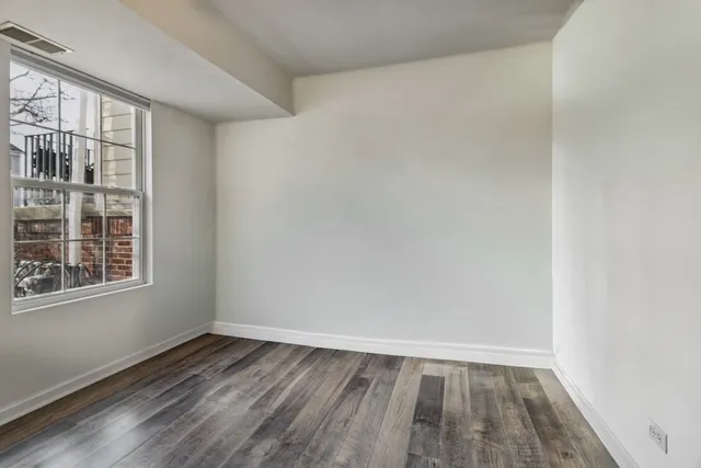 wooden floor in an empty room with a window