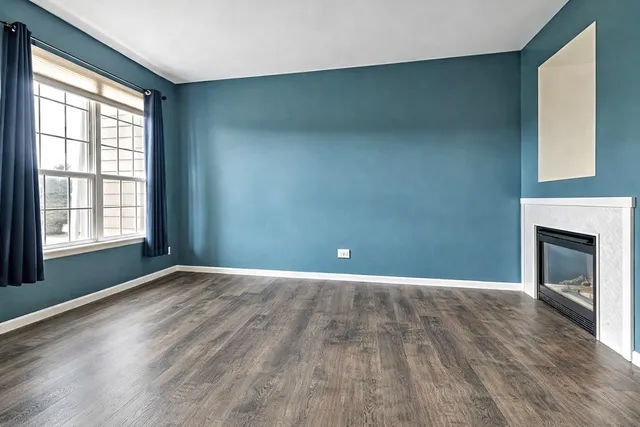 a view of an empty room with a window and fireplace