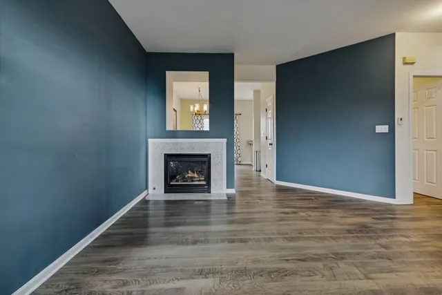 a view of an empty room with window and fire place