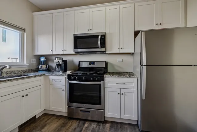 a kitchen with white cabinets and white appliances