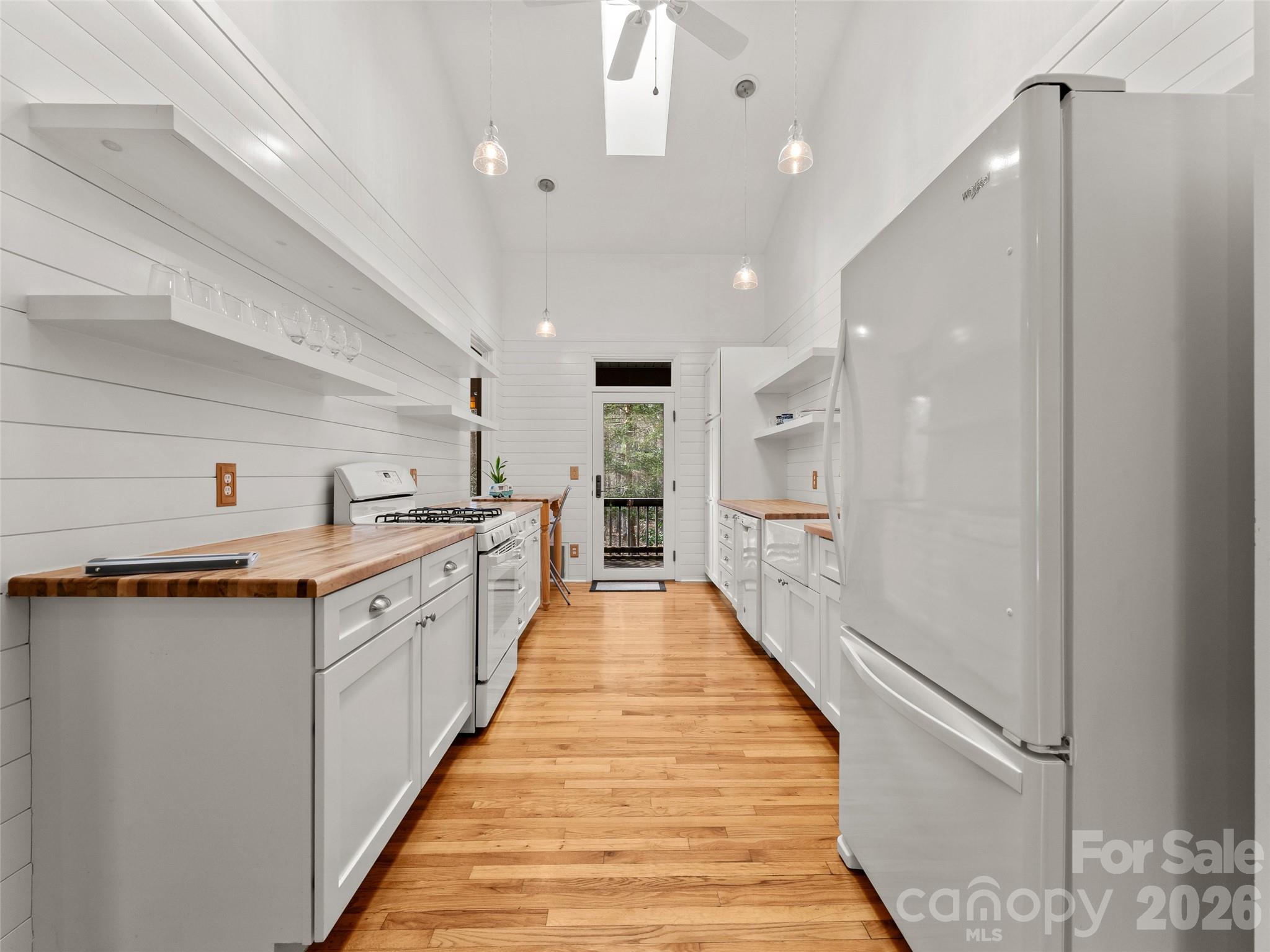203 Heathcote Road Hendersonville, NC 28791 - Photo 12 of 47 a large white kitchen with a sink and wooden floor