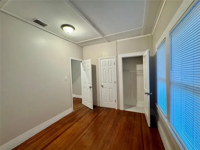a view of a hallway with wooden floor and closet