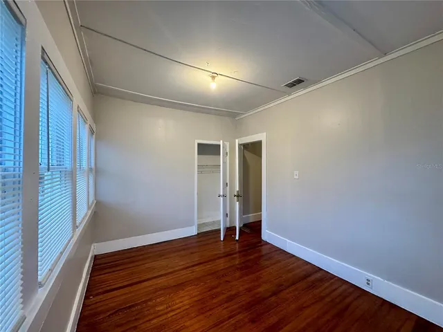 a view of empty room with wooden floor