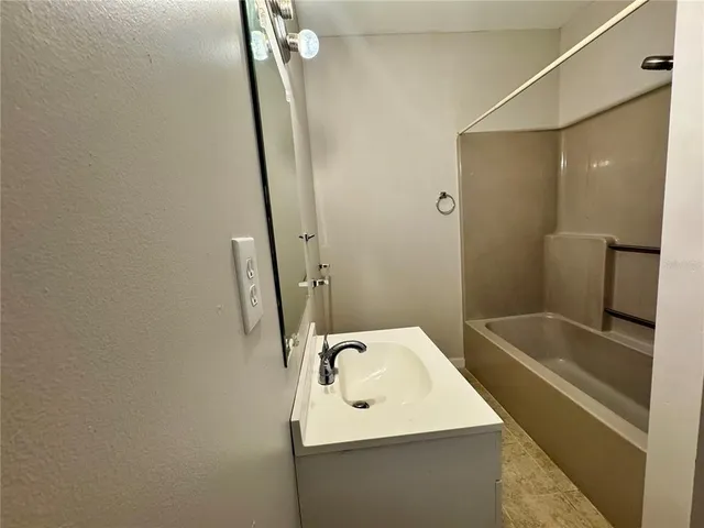 a bathroom with a sink a toilet a mirror and shower
