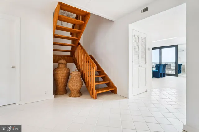 a view of a bedroom with staircase and white walls