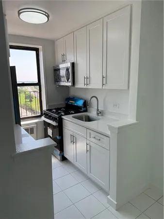 a kitchen with cabinets appliances a sink and a window