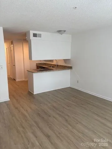 a kitchen with granite countertop a stove and a wooden floors