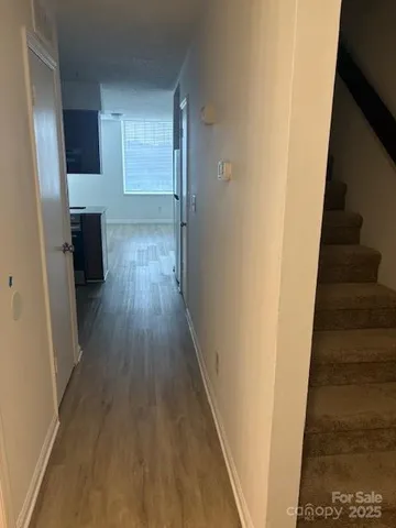 a view of a hallway with wooden floor and staircase
