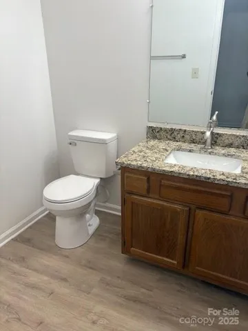 a bathroom with a granite countertop toilet and a sink