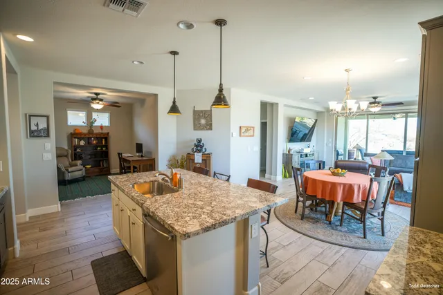 a kitchen with stainless steel appliances a dining table chairs stove and refrigerator