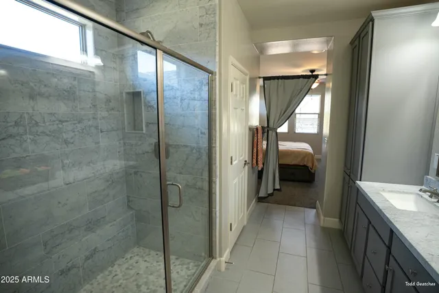 a bedroom with a large bed a chandelier and dresser